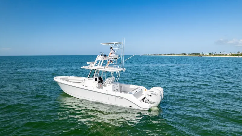 Slide: The Image of 2024 Edgewater 340CC boat cruising on open sea under clear blue sky. - 37