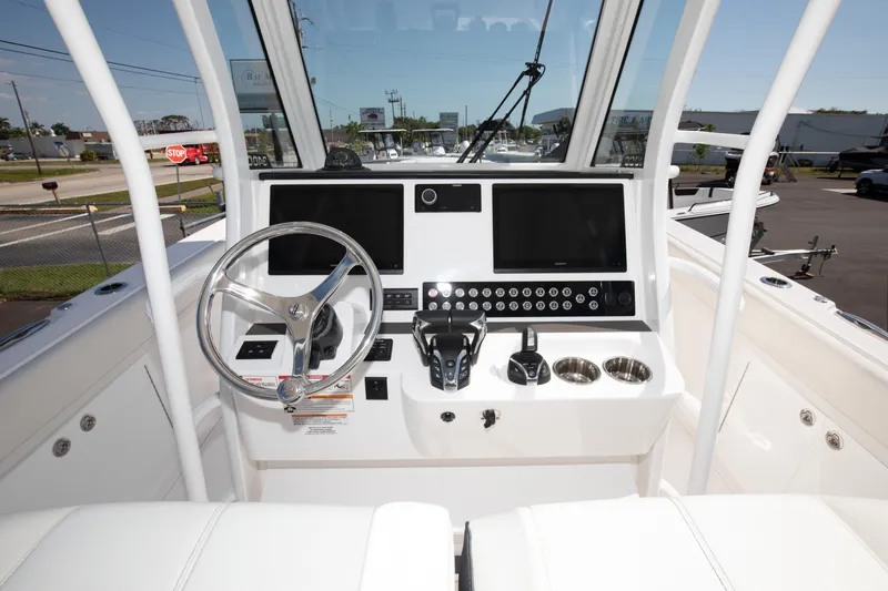 Slide: The Image of 2024 Edgewater 340CC boat helm with dual screens and steering wheel. - 5