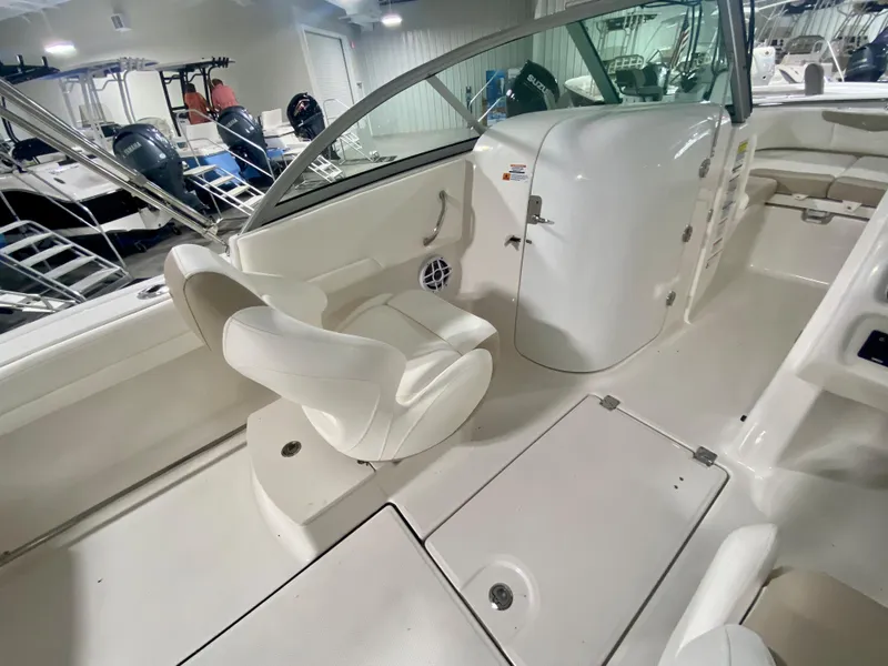 Slide: The Image of 2024 Robalo R207 Dual Console boat interior with white seating and storage compartments. - 12