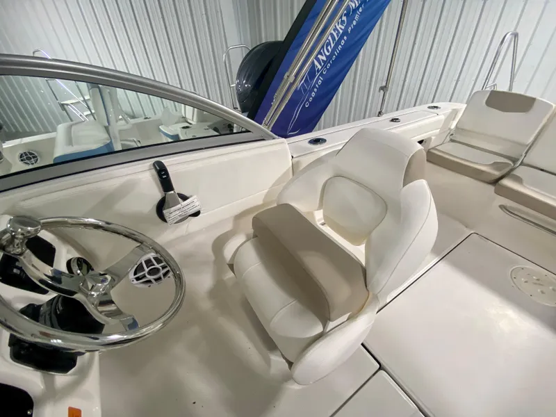 Slide: The Image of 2024 Robalo R207 Dual Console boat interior with steering wheel and seating. - 17