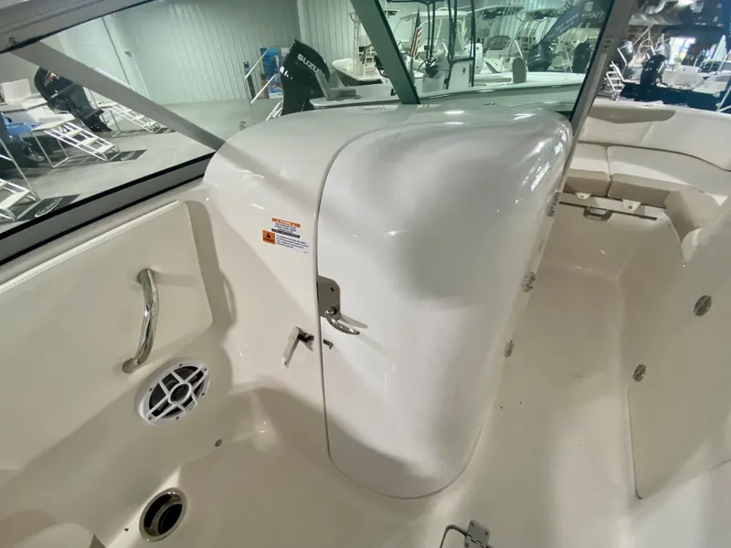 Slide: The Image of 2024 Robalo R207 Dual Console interior, white finish, spacious seating, and storage compartments. - 15