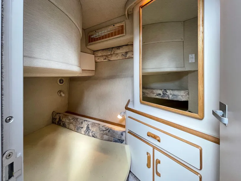 Slide: The Image of 1995 Sea Ray 370 Sedan Bridge cabin interior with bed, mirror, and storage cabinets. - 7