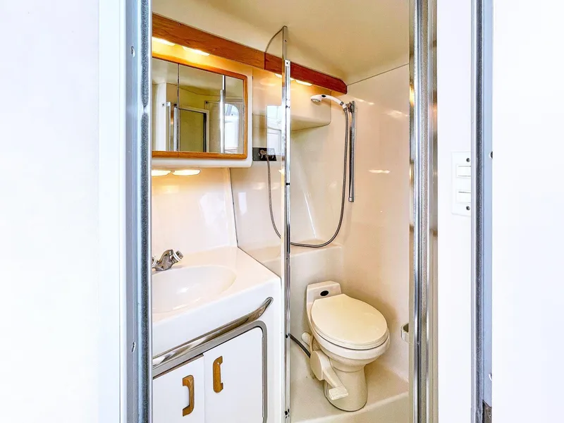 Slide: The Image of Bathroom interior of 1995 Sea Ray 370 Sedan Bridge yacht, featuring shower and toilet. - 8