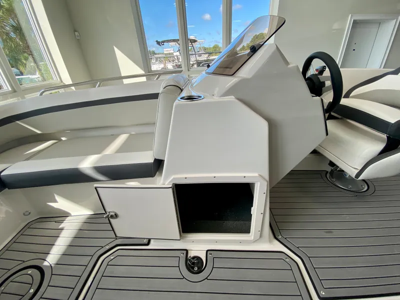 Slide: The Image of 2024 Starcraft SVX 211 Electric Blue Sport boat interior with open storage compartment. - 20
