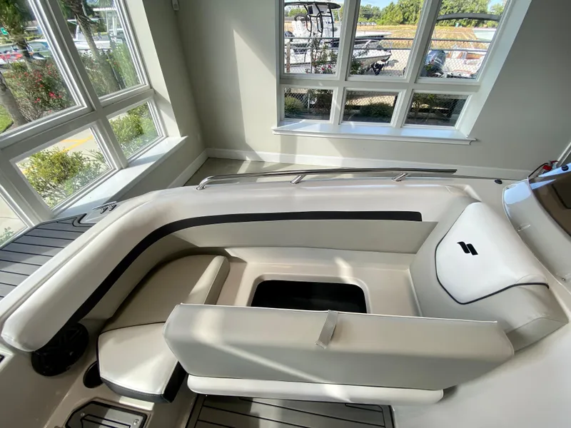 Slide: The Image of 2024 Starcraft SVX 211 Electric Blue Sport boat interior with seating and storage. - 24