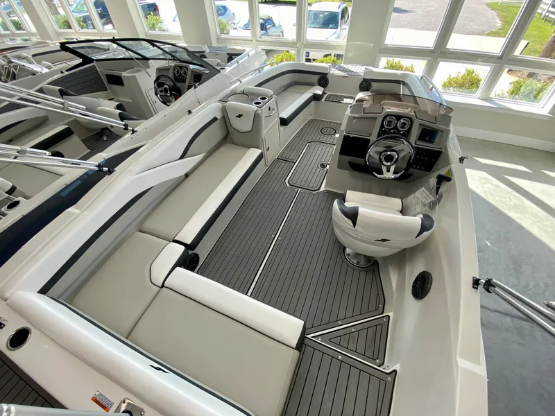 Slide: The Image of 2024 Starcraft SVX 211 Electric Blue Sport boat interior with modern seating and steering console. - 8