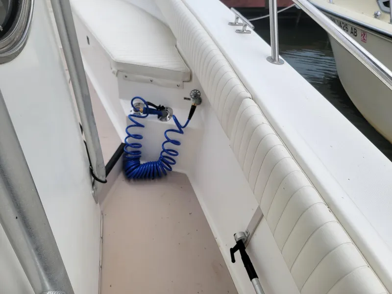 Slide: The Image of 1997 Albemarle 26 Center Console boat interior with white seating and blue coiled hose. - 21