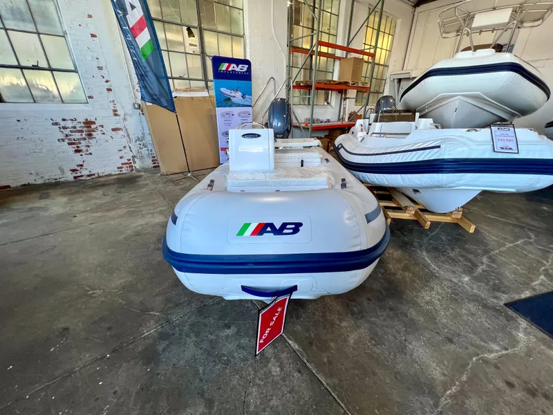 Slide: The Image of 2024 AB Inflatables Mares 12 VSX boat in stock, displayed in a showroom. - 2
