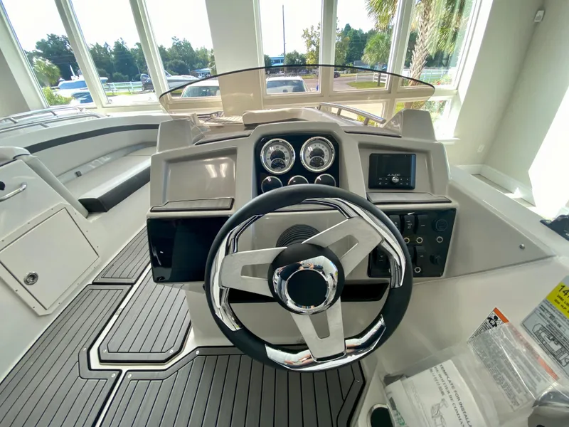 Slide: The Image of 2024 Starcraft SVX 211 Electric Blue Sport boat dashboard and steering wheel. - 15