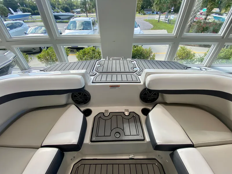 Slide: The Image of 2024 Starcraft SVX 211 Electric Blue Sport boat interior with cushioned seating and storage compartments. - 27