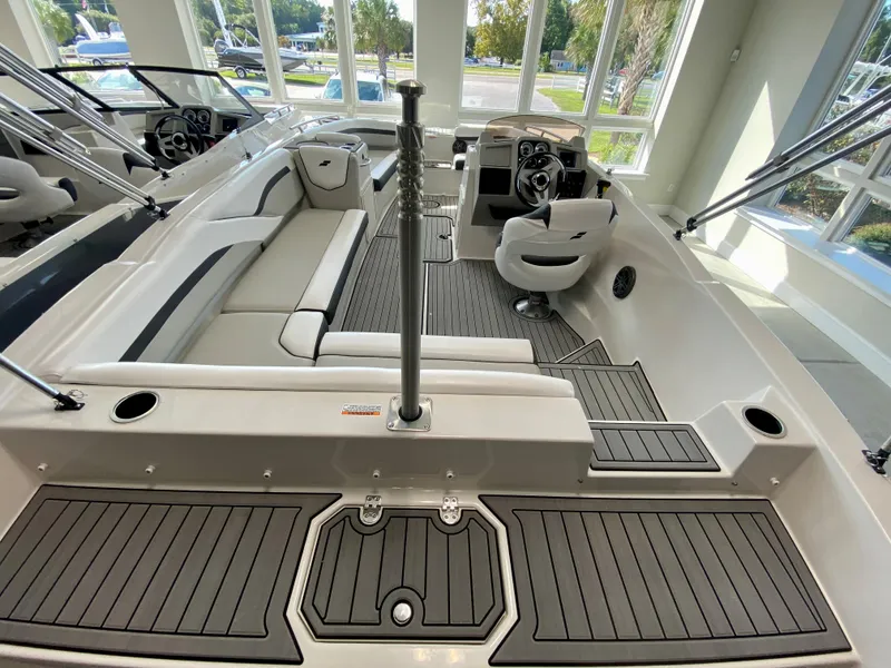 Slide: The Image of 2024 Starcraft SVX 211 Electric Blue Sport boat interior with seating and steering console. - 6