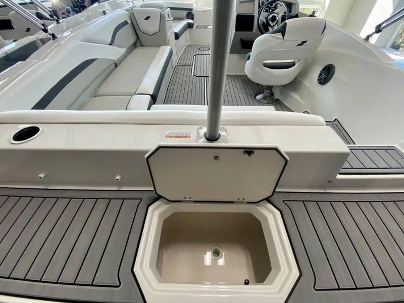 Slide: The Image of 2024 Starcraft SVX 211 Electric Blue Sport boat interior with seating and steering wheel. - 7