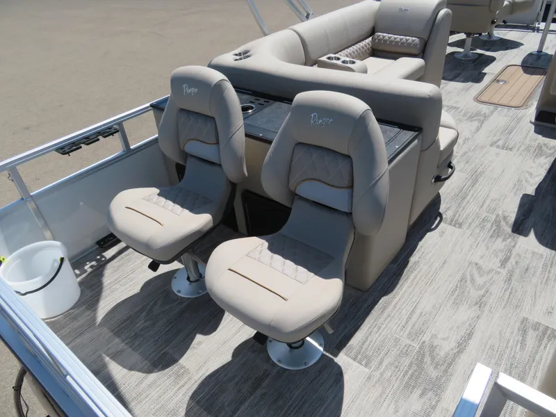 Slide: The Image of 2024 Ranger 223FC boat interior with beige captain chairs and seating area. - 10