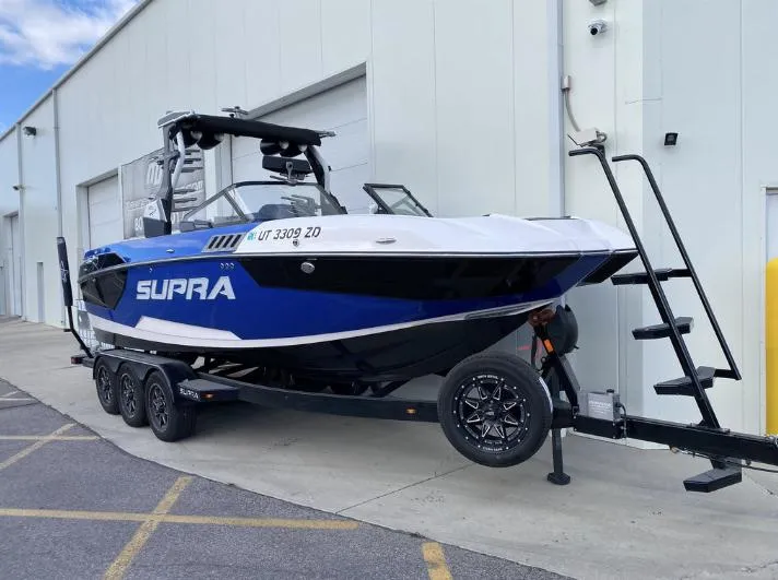 Slide: The Image of 2022 Supra SE boat on trailer outside a building. - 3