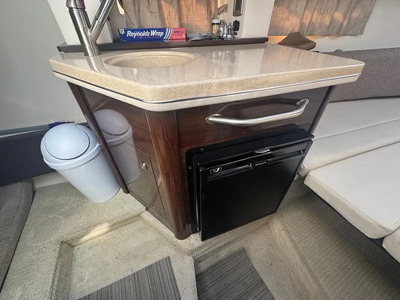 Slide: The Image of 2015 Sea Ray 260 Sundancer interior with kitchenette, sink, and mini fridge. - 11