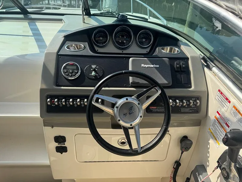 Slide: The Image of 2015 Sea Ray 260 Sundancer dashboard with steering wheel and Raymarine navigation system. - 16