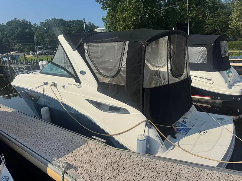 Slide: The Image of 2015 Sea Ray 260 Sundancer docked with black canopy, side view. - 2