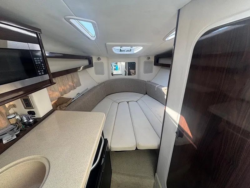 Slide: The Image of 2015 Sea Ray 260 Sundancer cabin interior with kitchenette and seating area. - 6