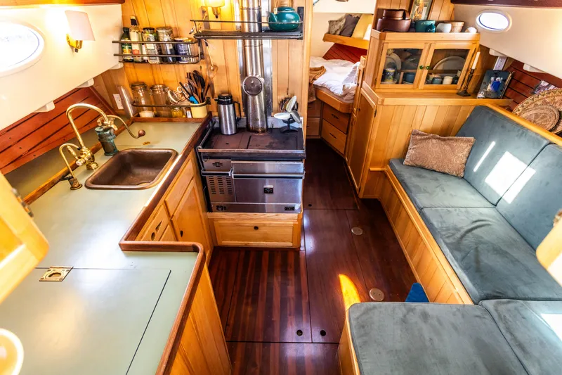 Slide: The Image of Interior of 2009 Custom Gartside Downeast Cruiser with wooden cabinetry, kitchen, and seating area. - 12