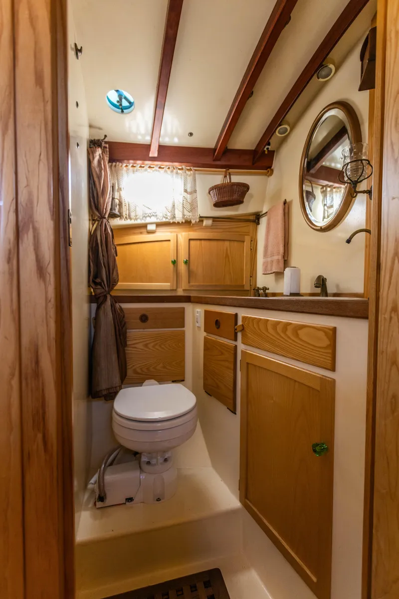 Slide: The Image of 2009 Custom Gartside Downeast Cruiser bathroom with wooden cabinetry and nautical decor. - 14