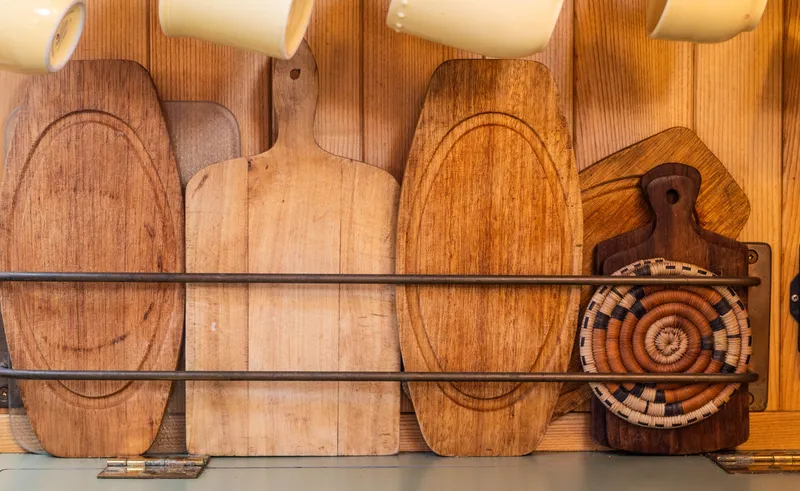 Slide: The Image of Wooden cutting boards and woven trivet in a 2009 Custom Gartside Downeast Cruiser kitchen. - 23