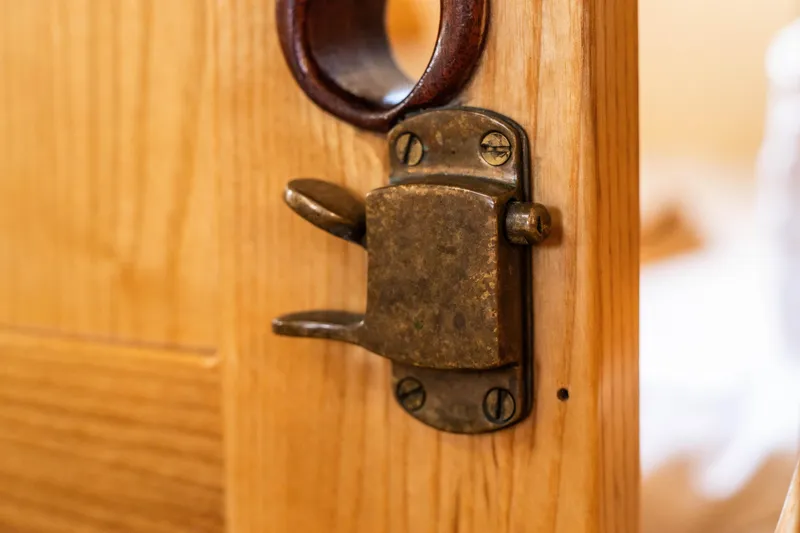 Slide: The Image of Close-up of vintage brass latch on wooden door of 2009 Custom Gartside Downeast Cruiser. - 24