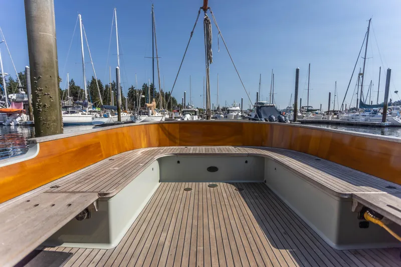 Slide: The Image of 2009 Custom Gartside Downeast Cruiser with wooden deck and seating, docked at a marina. - 33