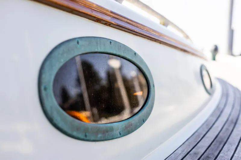Slide: The Image of Close-up of 2009 Custom Gartside Downeast Cruiser's porthole and wooden deck. - 44