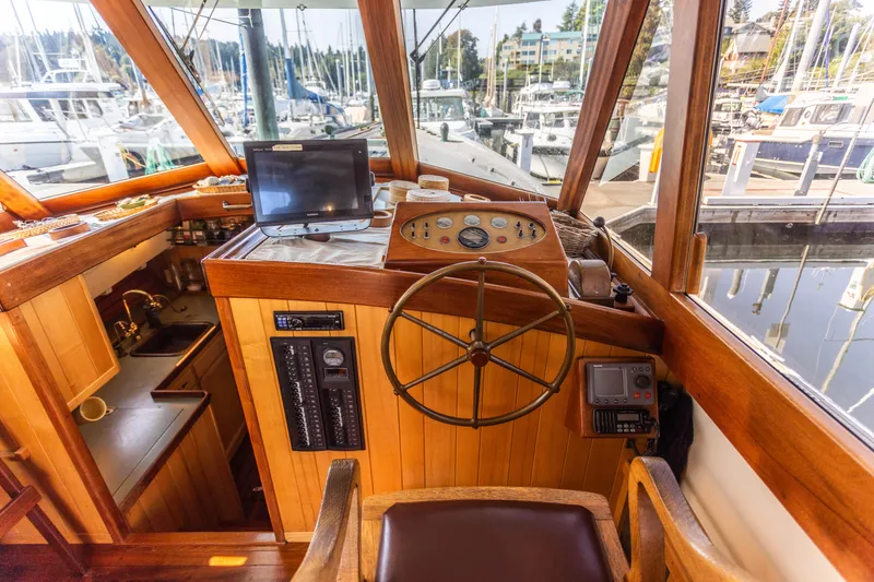 Slide: The Image of 2009 Custom Gartside Downeast Cruiser helm station with wooden steering wheel and navigation equipment. - 8