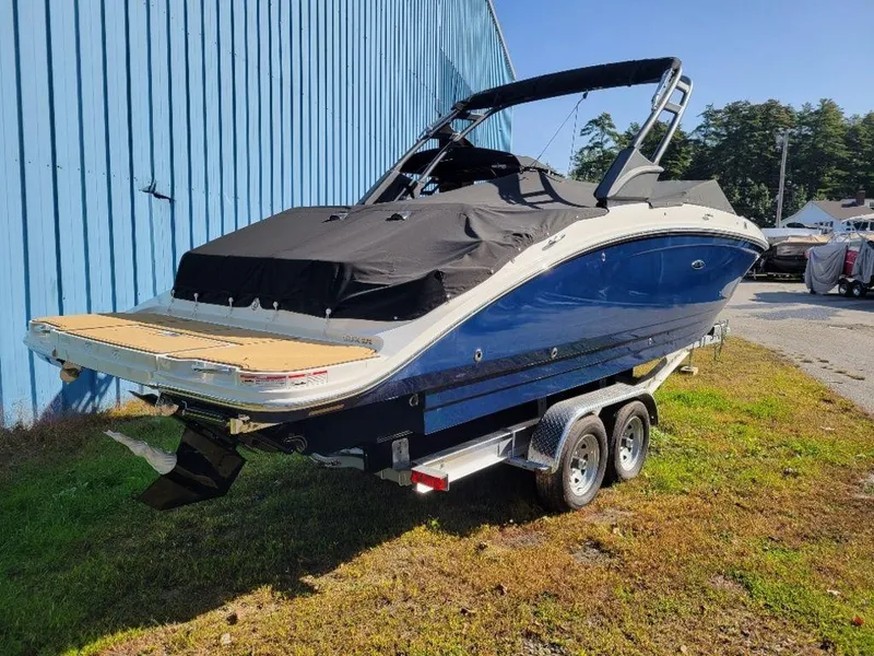 Slide: The Image of 2024 Sea Ray SDX 270 boat on a trailer, covered and parked outdoors. - 11
