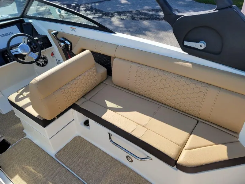 Slide: The Image of 2024 Sea Ray SDX 270 boat interior with beige seating and steering console. - 2