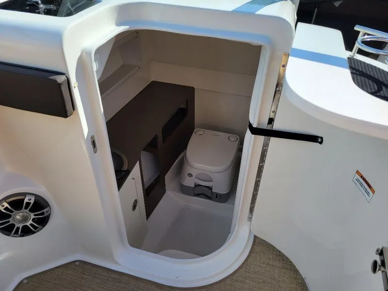 Slide: The Image of 2024 Sea Ray SDX 270 boat interior with compact toilet and storage. - 6