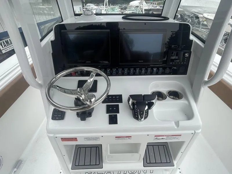 Slide: The Image of 2024 Sea Hunt Gamefish 27 FS helm with dual displays and controls. - 7