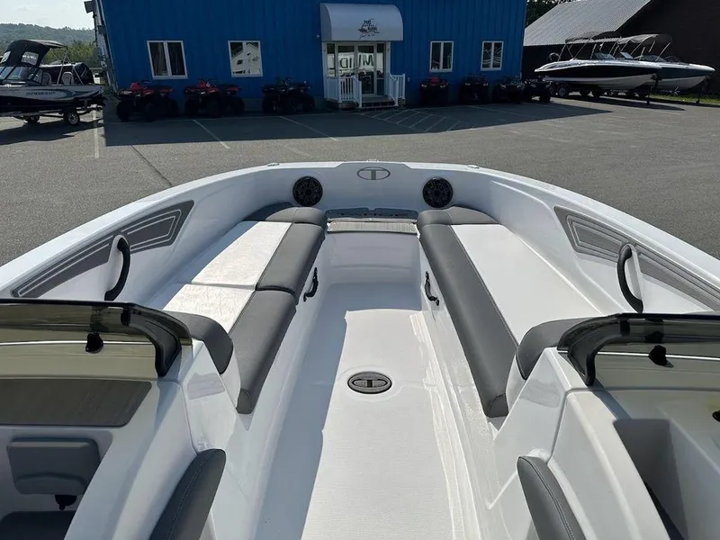 Slide: The Image of 2024 Tahoe T21 boat interior with seating and speakers, parked outside a blue building. - 8