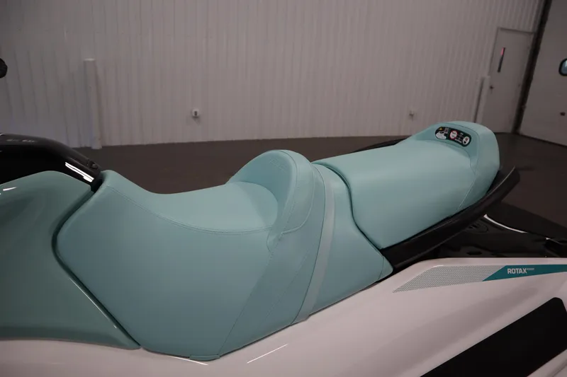 Slide: The Image of 2025 Sea-Doo GTI™ 130 jet ski with teal seat in a showroom. - 10