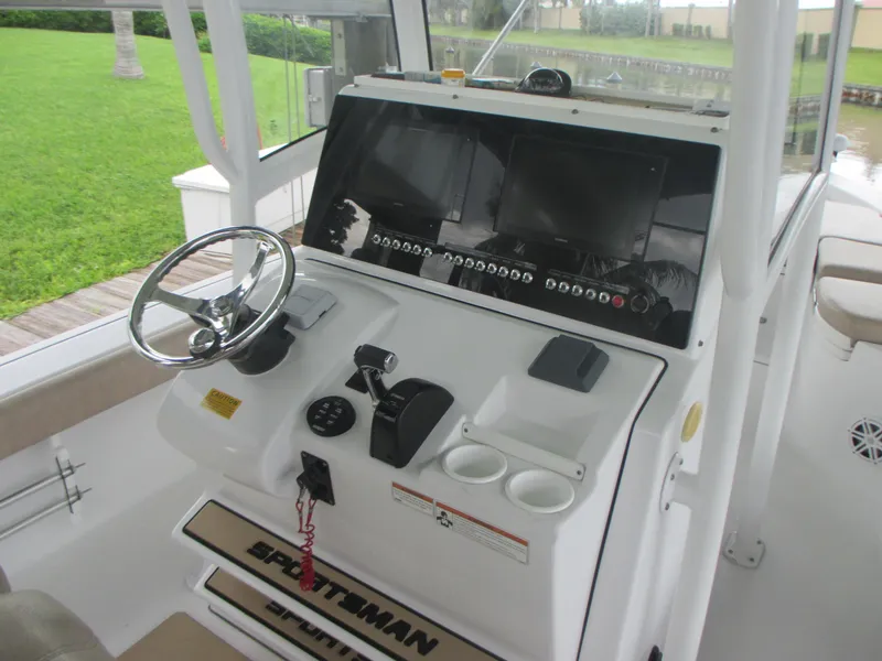 Slide: The Image of 2019 Sportsman 267 Masters boat helm with steering wheel, dual screens, and control panel. - 4