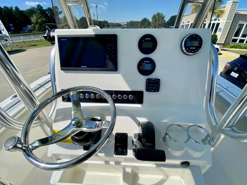 Slide: The Image of 2024 Key West 219 FS boat dashboard with steering wheel, gauges, and navigation screen. - 12