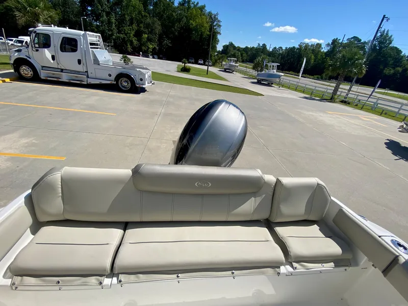 Slide: The Image of 2024 Key West 219 FS boat with rear seating and outboard motor in parking lot. - 7