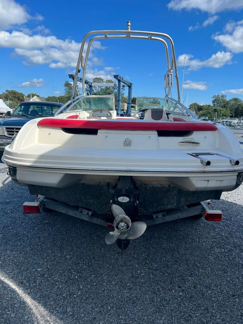 Slide: The Image of 2006 Sea Ray 205 Sport boat, rear view, parked on gravel, clear sky background. - 2