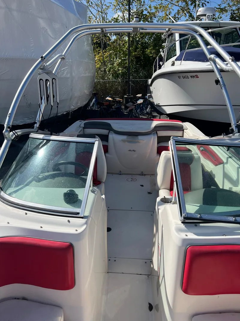Slide: The Image of 2006 Sea Ray 205 Sport boat with red and white interior, docked outdoors. - 7