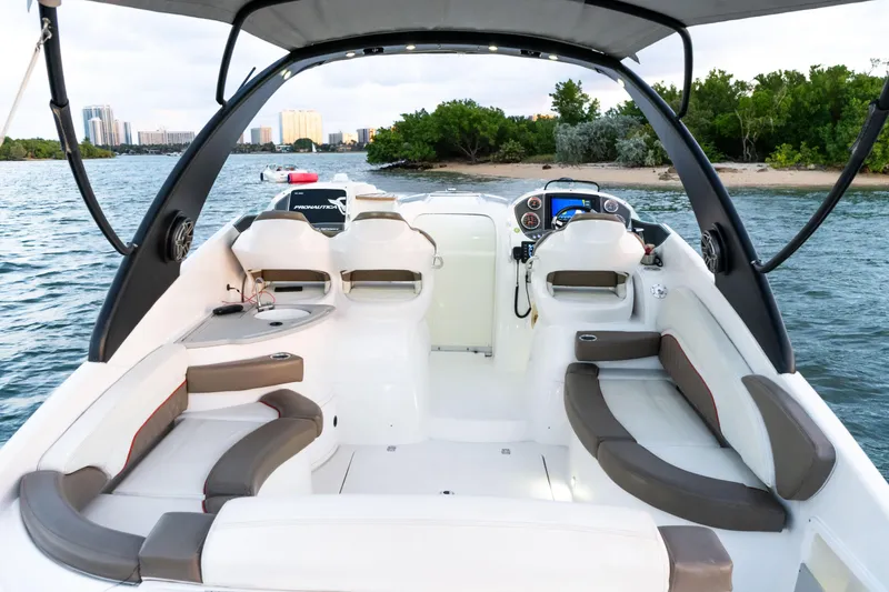 Slide: The Image of 2018 Pronautica 1260 Super Sport boat interior with seating and dashboard, on water near shoreline. - 20