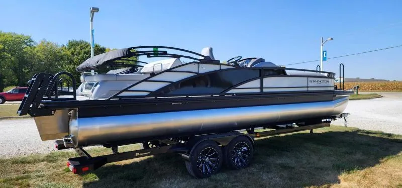 Slide: The Image of 2024 Bennington 25 RTSB pontoon boat on a trailer, side view. - 1