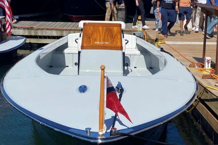 Slide: The Image of 2024 C.W. Hood 26E Electric Runabout docked, showcasing sleek design and modern features. - 4