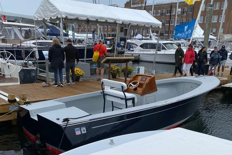 Slide: The Image of 2024 C.W. Hood 26E Electric Runabout docked at a marina with people nearby. - 7
