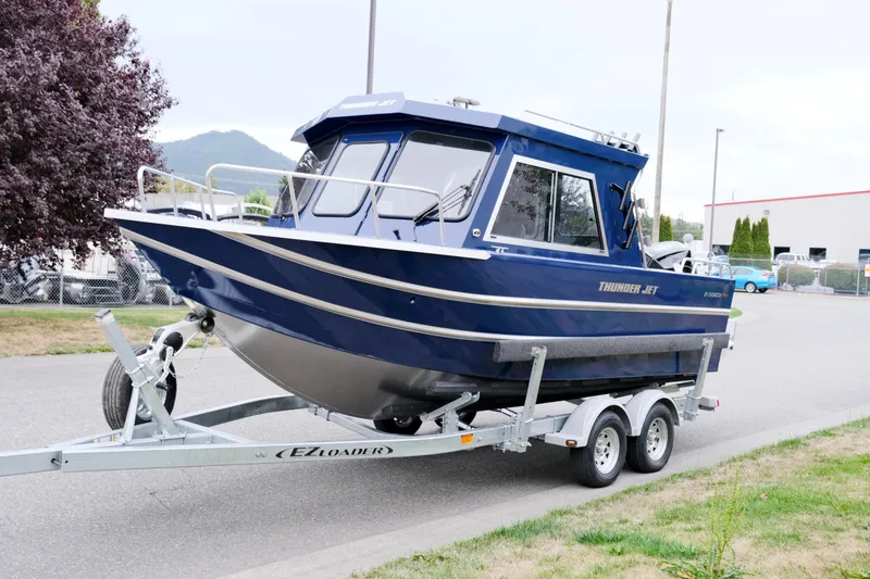 Slide: The Image of 2024 Thunder Jet 21 Chinook Pro boat on trailer, blue exterior, parked outdoors. - 3