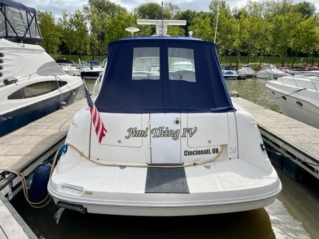Slide: The Image of 2007 Sea Ray 38 Sundancer docked, rear view with blue cover and American flag. - 1