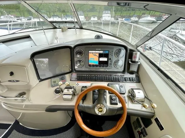 Slide: The Image of 2007 Sea Ray 38 Sundancer helm with navigation controls and wooden steering wheel. - 11