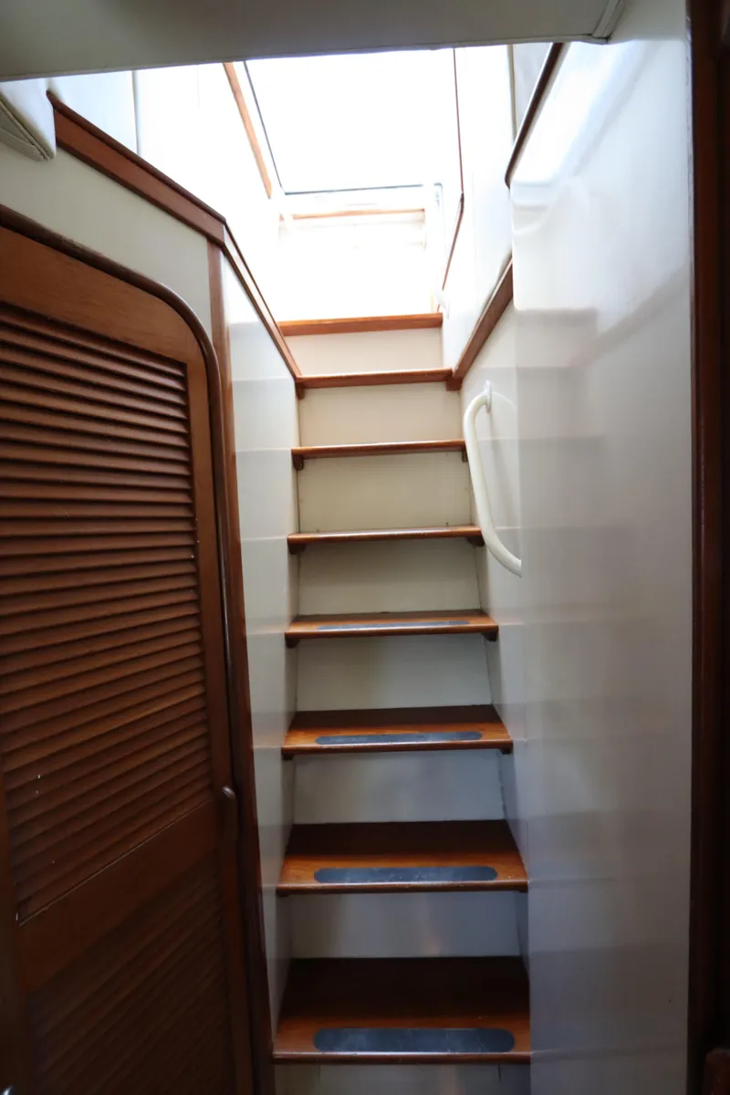 Slide: The Image of Staircase inside 1991 Viking Motor Yacht with wooden steps and handrail. - 11