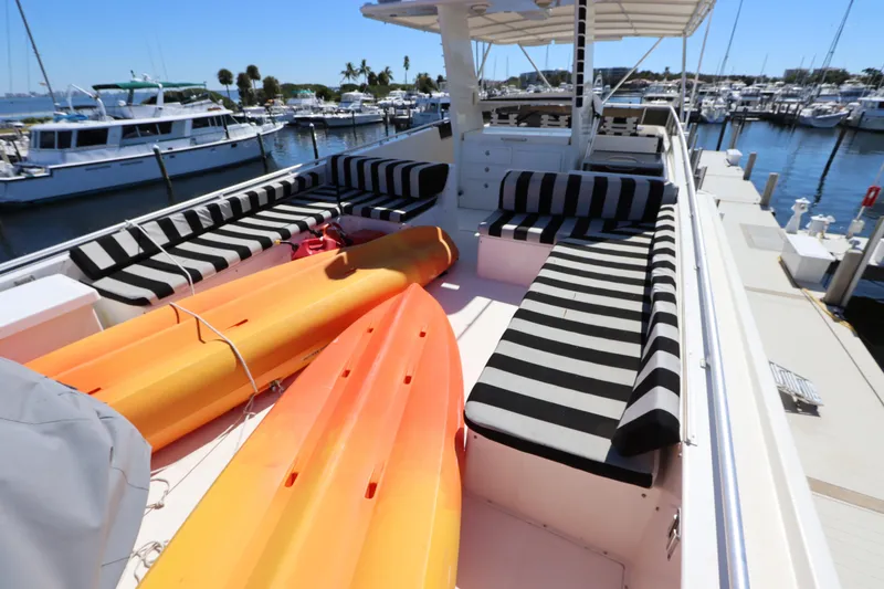 Slide: The Image of 1991 Viking Motor Yacht with striped seating and kayaks on deck at marina. - 13