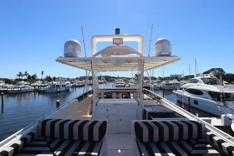 Slide: The Image of 1991 Viking Motor Yacht docked at a marina with striped seating and clear blue skies. - 14